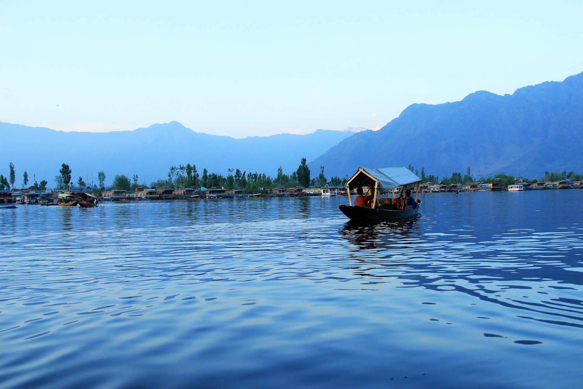 people riding boat on body of water near island